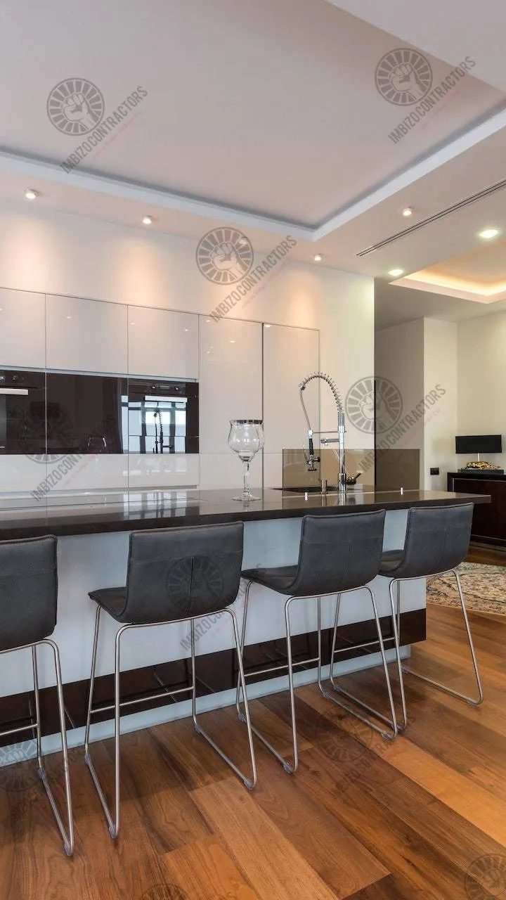 Modern kitchen renovation with island, bar stools and LED lighting.